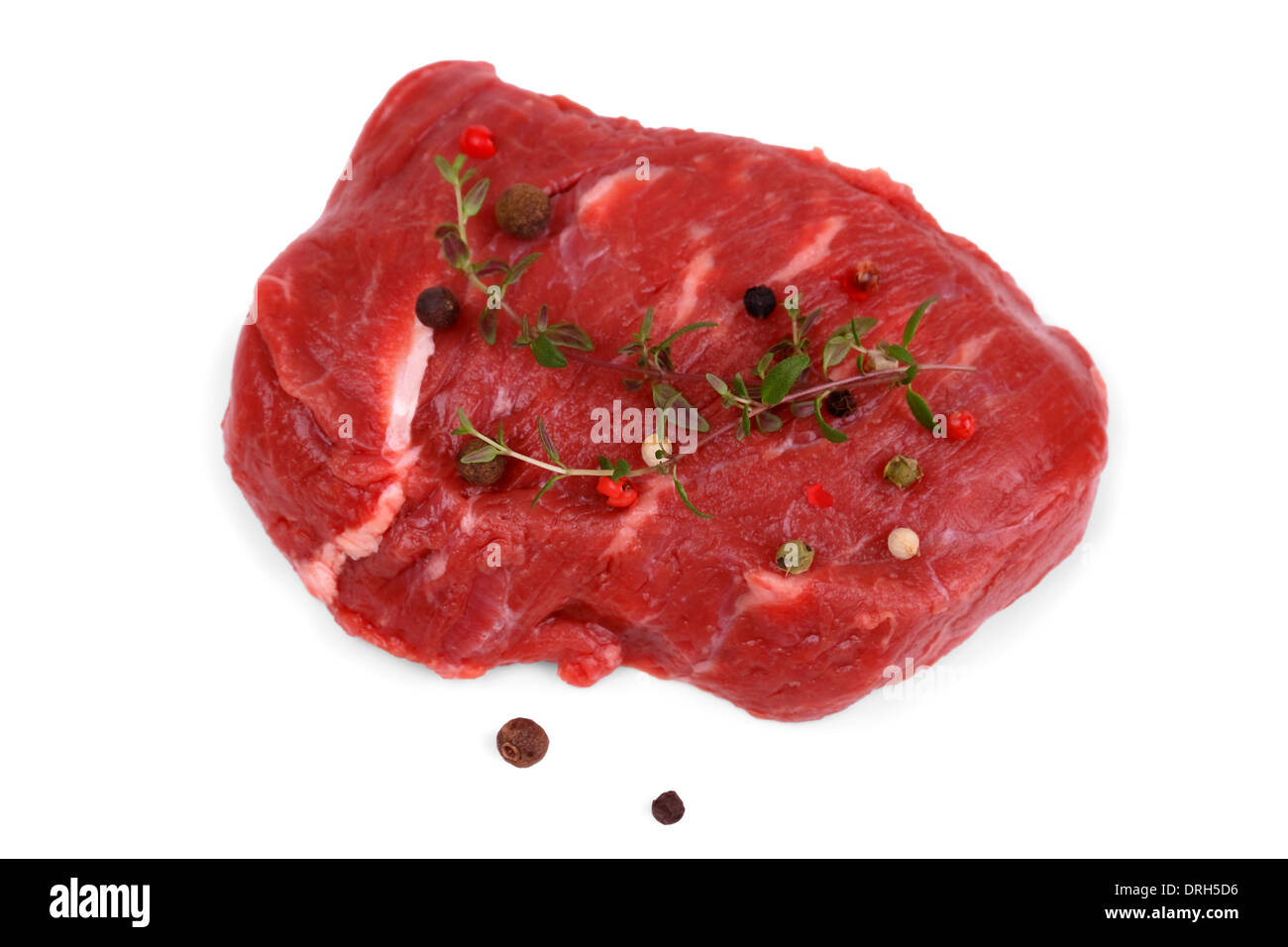 Steak de bœuf juteux avec des grains de poivre et le thym, isolé Banque D'Images