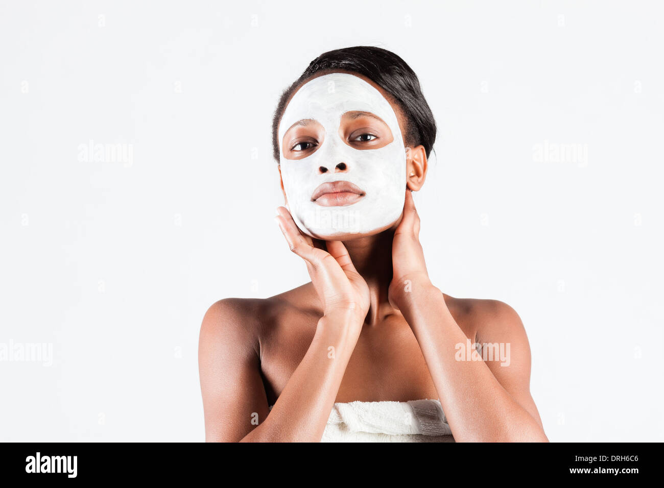 Jeune femme africaine en Studio faisant corps avec le masque facial rafraîchissant pour les jeunes et une belle peau et de détente Banque D'Images