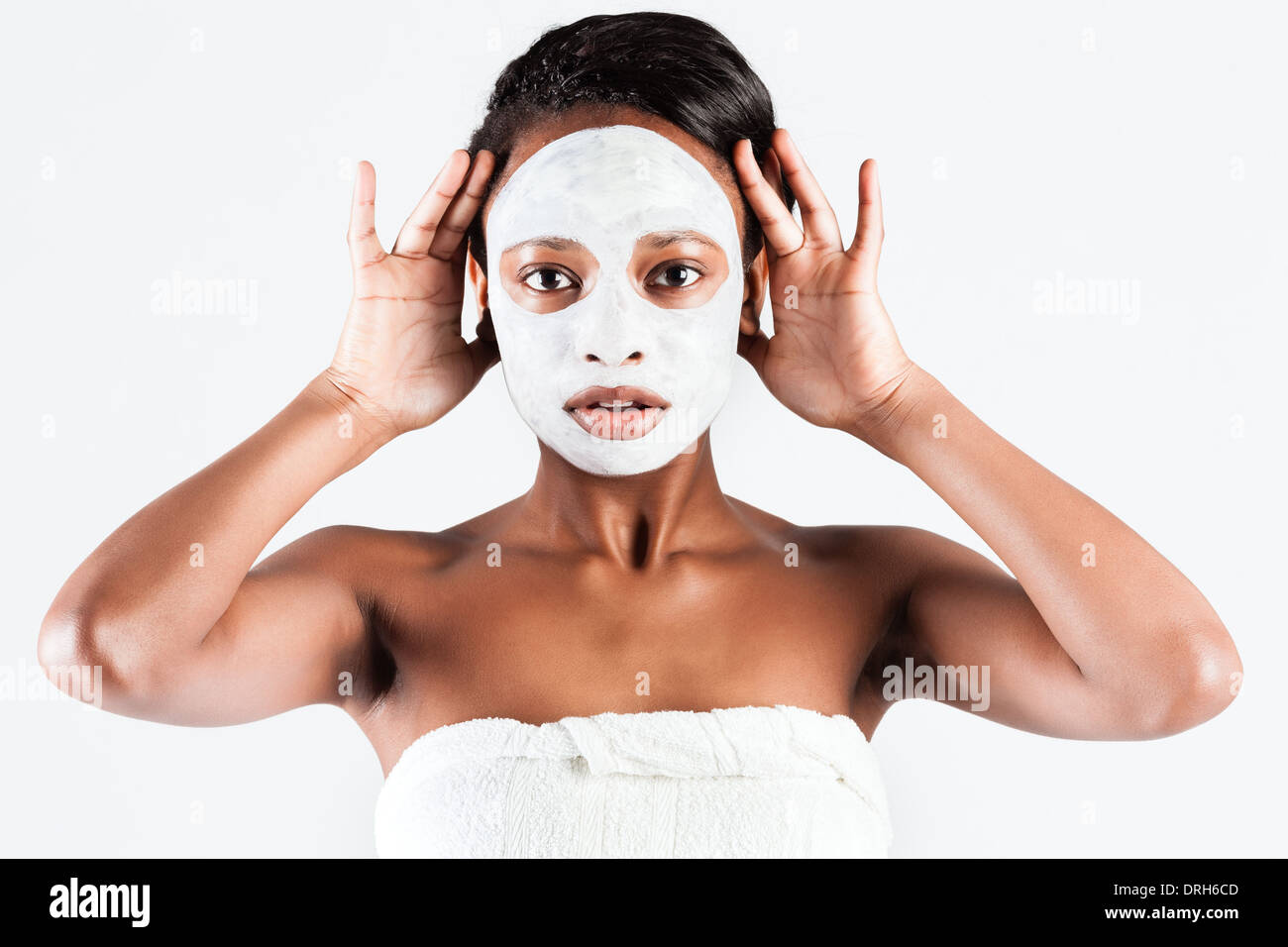 Jeune femme africaine en Studio faisant corps avec le masque facial rafraîchissant pour les jeunes et une belle peau et de détente Banque D'Images