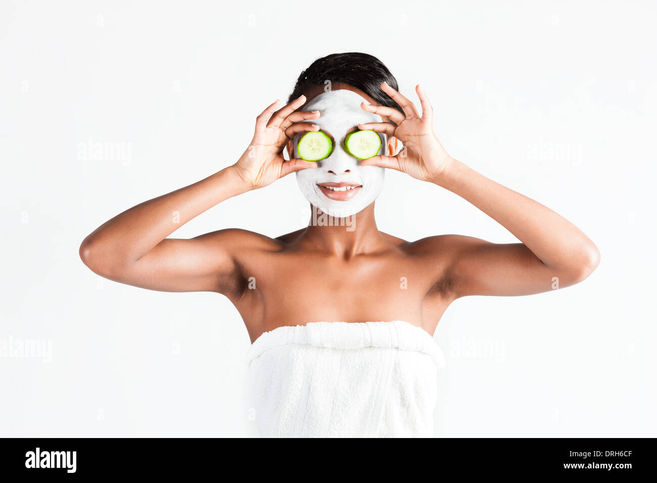 Jeune femme africaine en Studio faisant corps avec le concombre masque facial rafraîchissant pour les jeunes et une belle peau et de détente Banque D'Images