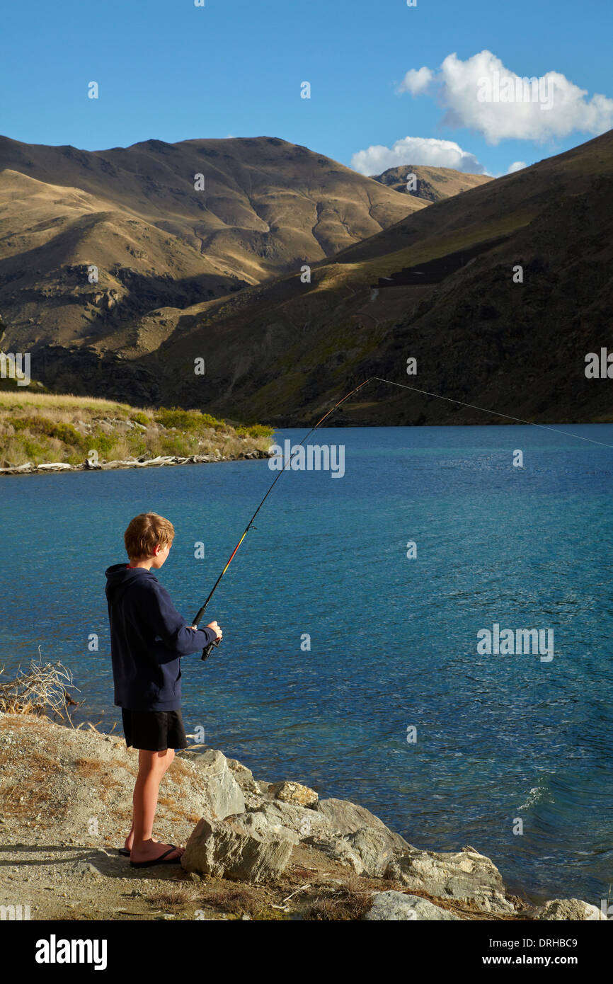 Garçon de pêche dans le lac Dunstan, Central Otago, île du Sud, Nouvelle-Zélande Banque D'Images