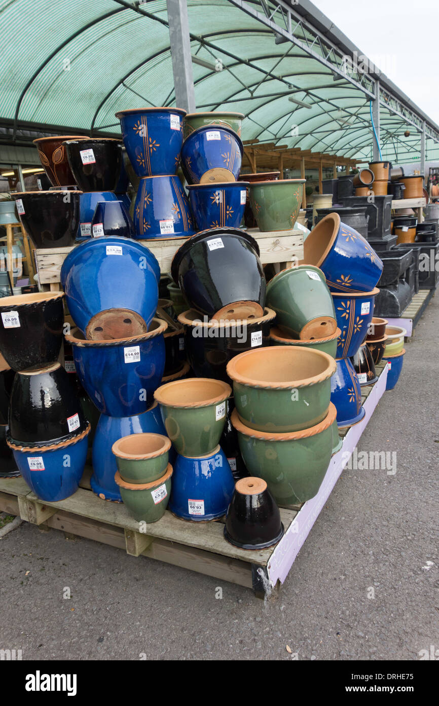 Un tas de couleurs bleu vert et noir en argile émaillée pots de fleurs sur offre spéciale dans un centre de jardinage Banque D'Images