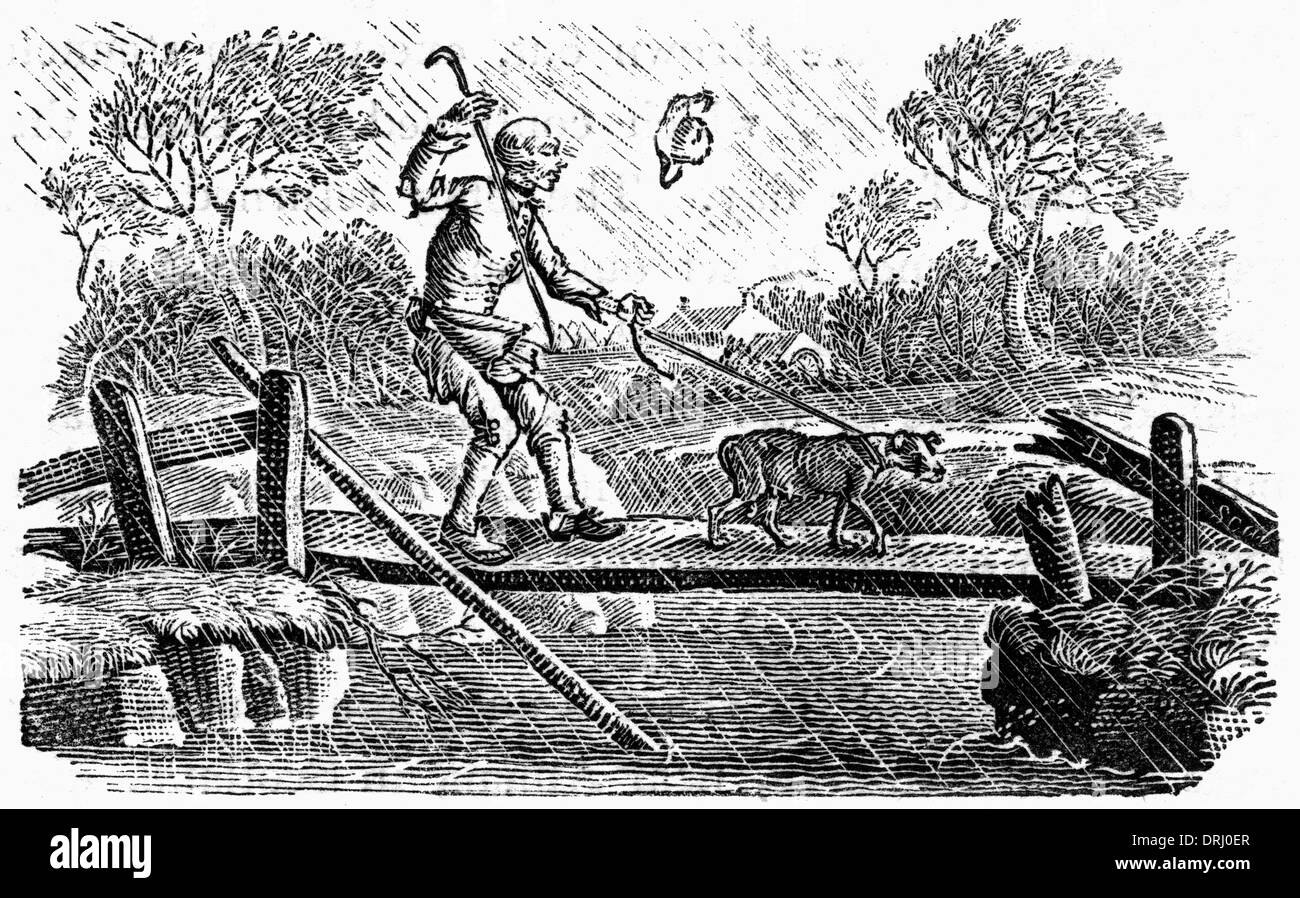 L'homme et le chien crossing bridge en pleine tempête Banque D'Images