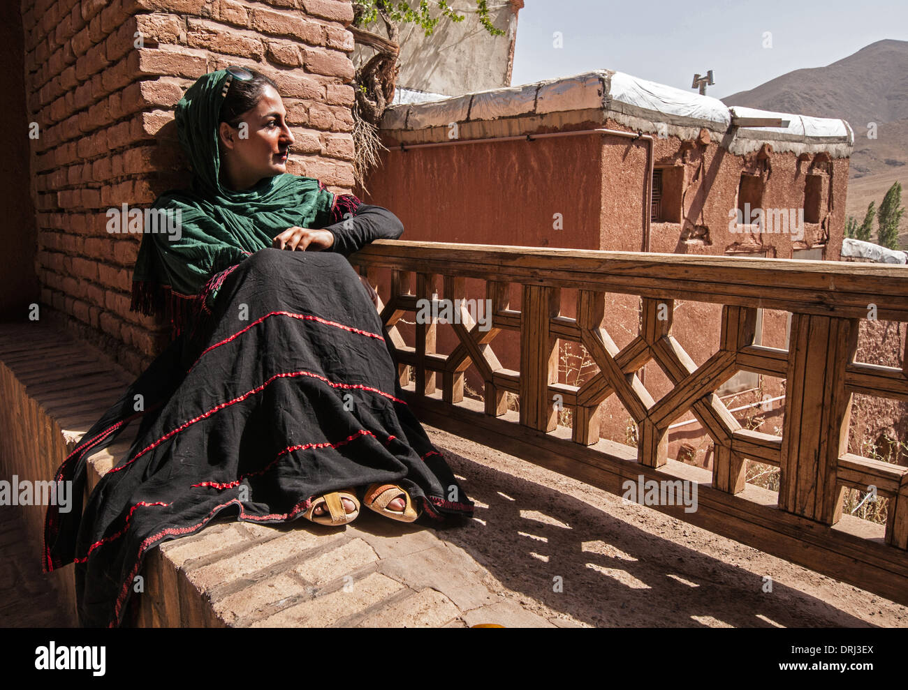 Une femme avec un foulard vert sur balustrade à Abyaneh, Ostan-e Esfahan, Iran Banque D'Images