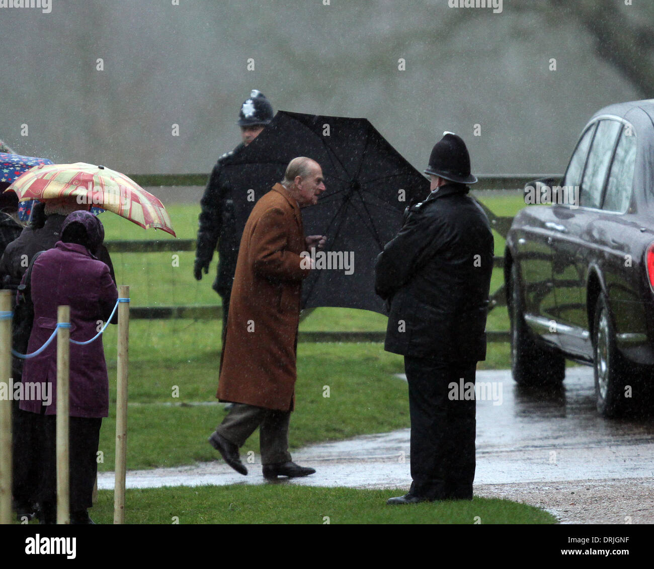Sandringham, Norfolk, Royaume-Uni. 26 janvier, 2014. Sa Majesté la Reine Elizabeth II à l'église de Sandringham. Le prince Philip, duc d'Édimbourg, tient à son parapluie avant de fréquenter l'Eglise Sainte-marie Madeleine pour dimanche matin à Sandringham. Pic : Paul Marriott Photography/Alamy Live News Banque D'Images