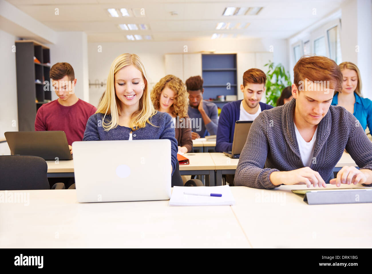 De nombreux étudiants à l'école travailler avec les ordinateurs et tablettes Banque D'Images