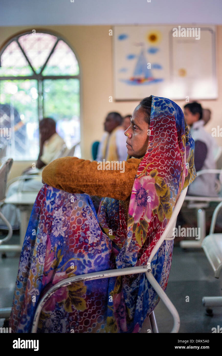 Femme indienne attente patiente dans la salle d'enregistrement Super hôpital spécialisé. Puttaparthi, Andhra Pradesh, Inde Banque D'Images