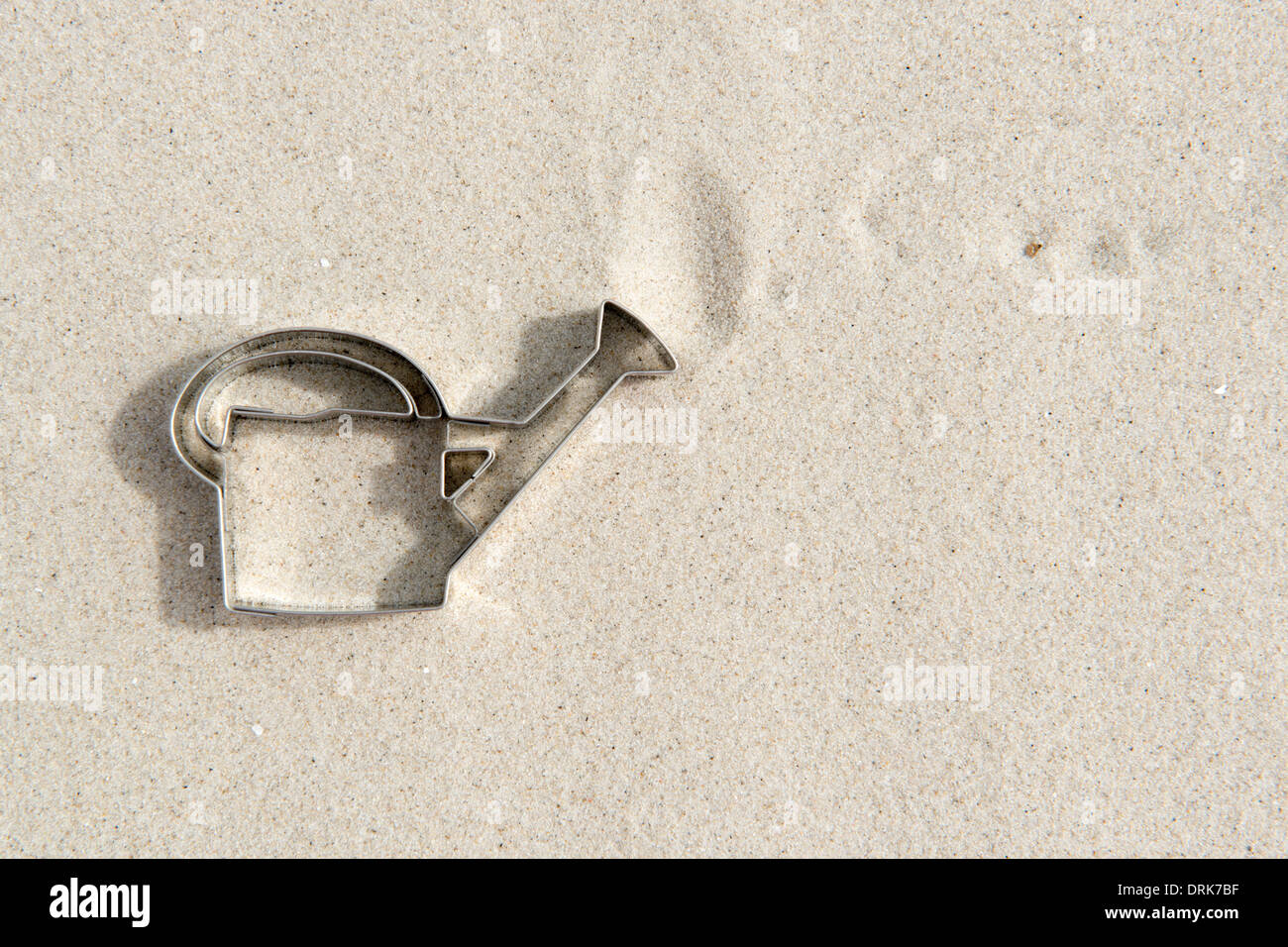 Emporte-pièce en forme d'arrosoir sur le sable Banque D'Images