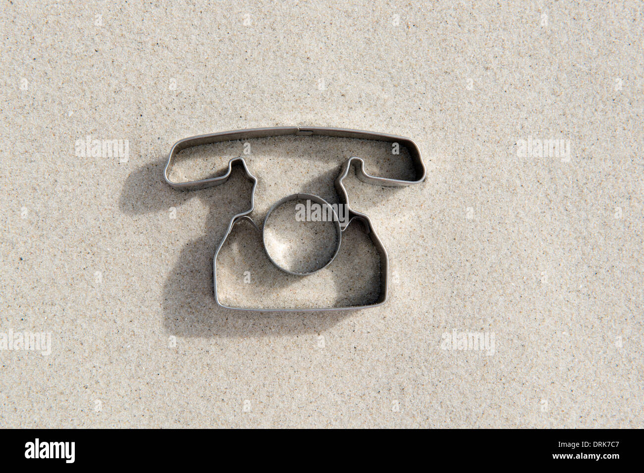 Emporte-pièce en forme de téléphone sur le sable Banque D'Images