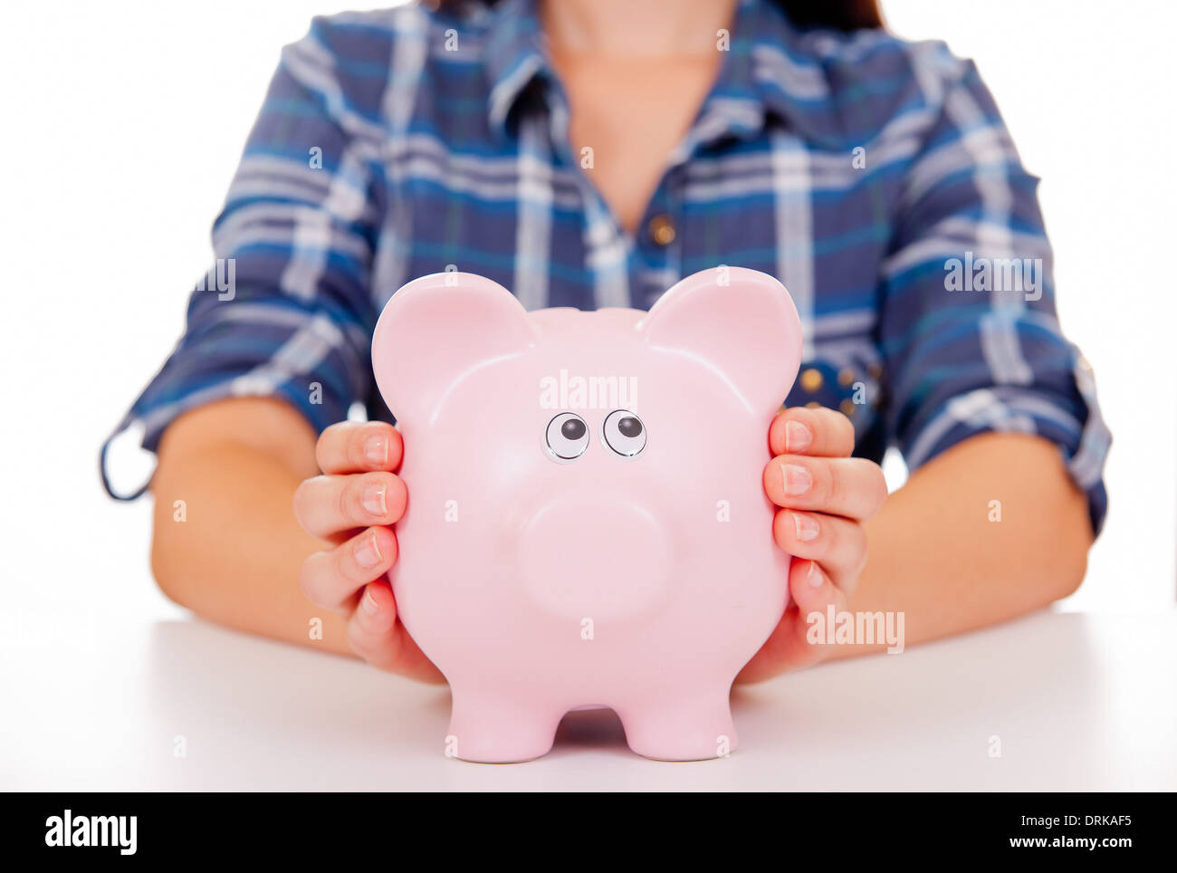 Jeune fille/femme avec ses mains tenant sur un grand pink piggy bank. Banque D'Images