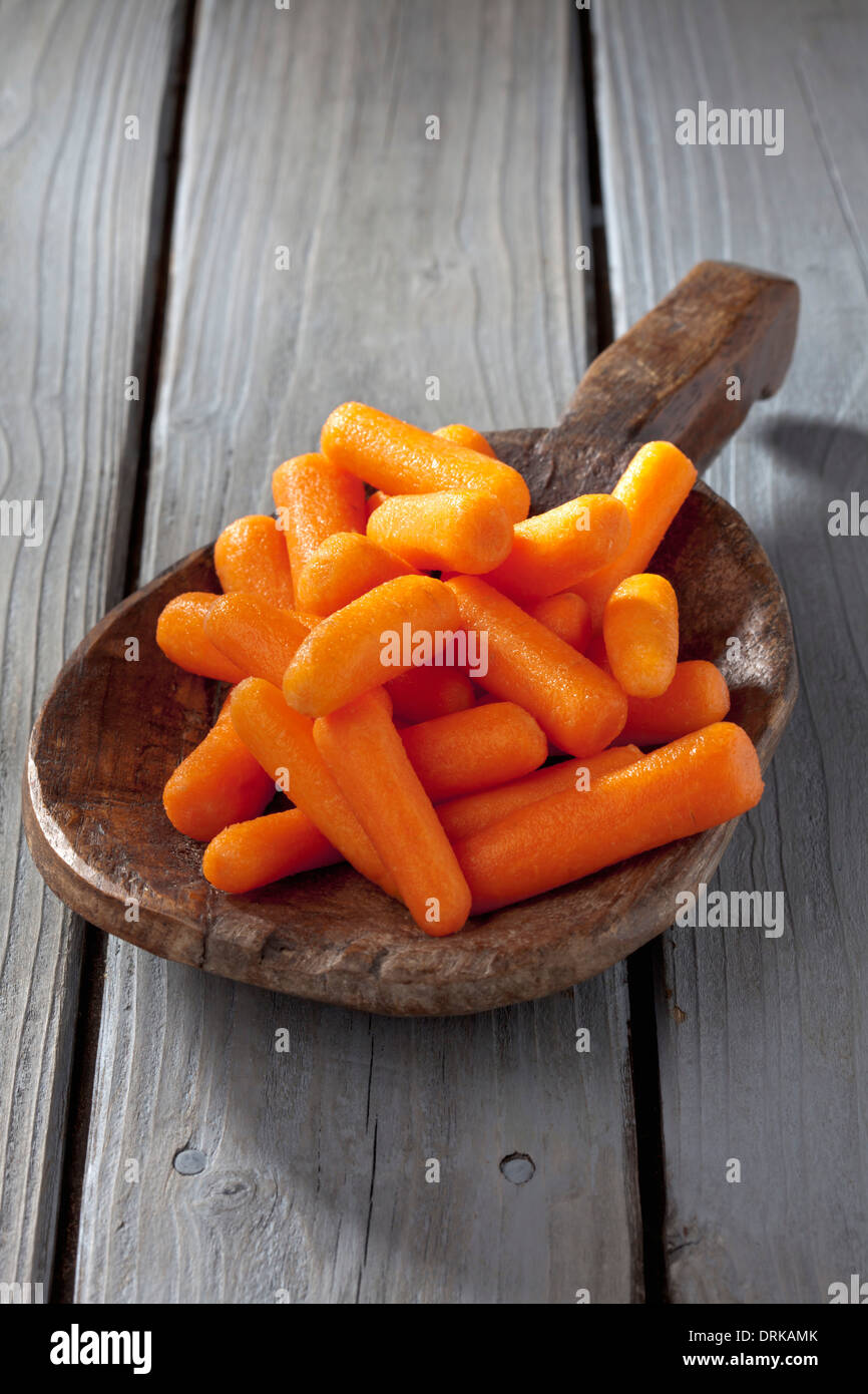 Prêt à manger des carottes sur cuillère en bois Banque D'Images