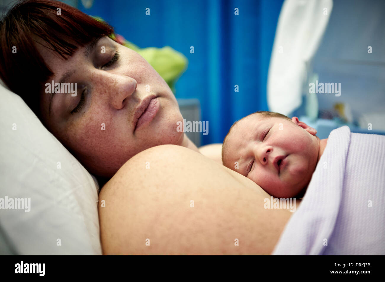 Un nouveau né dort sur sa mère. Banque D'Images