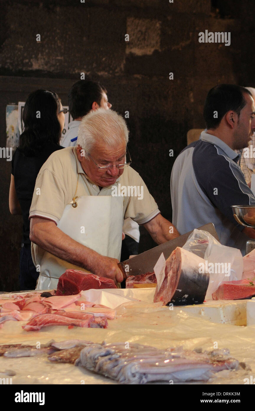 Les vendeurs de poisson couper le poisson dans la pescheria, marché aux poissons Catane, Sicile Banque D'Images