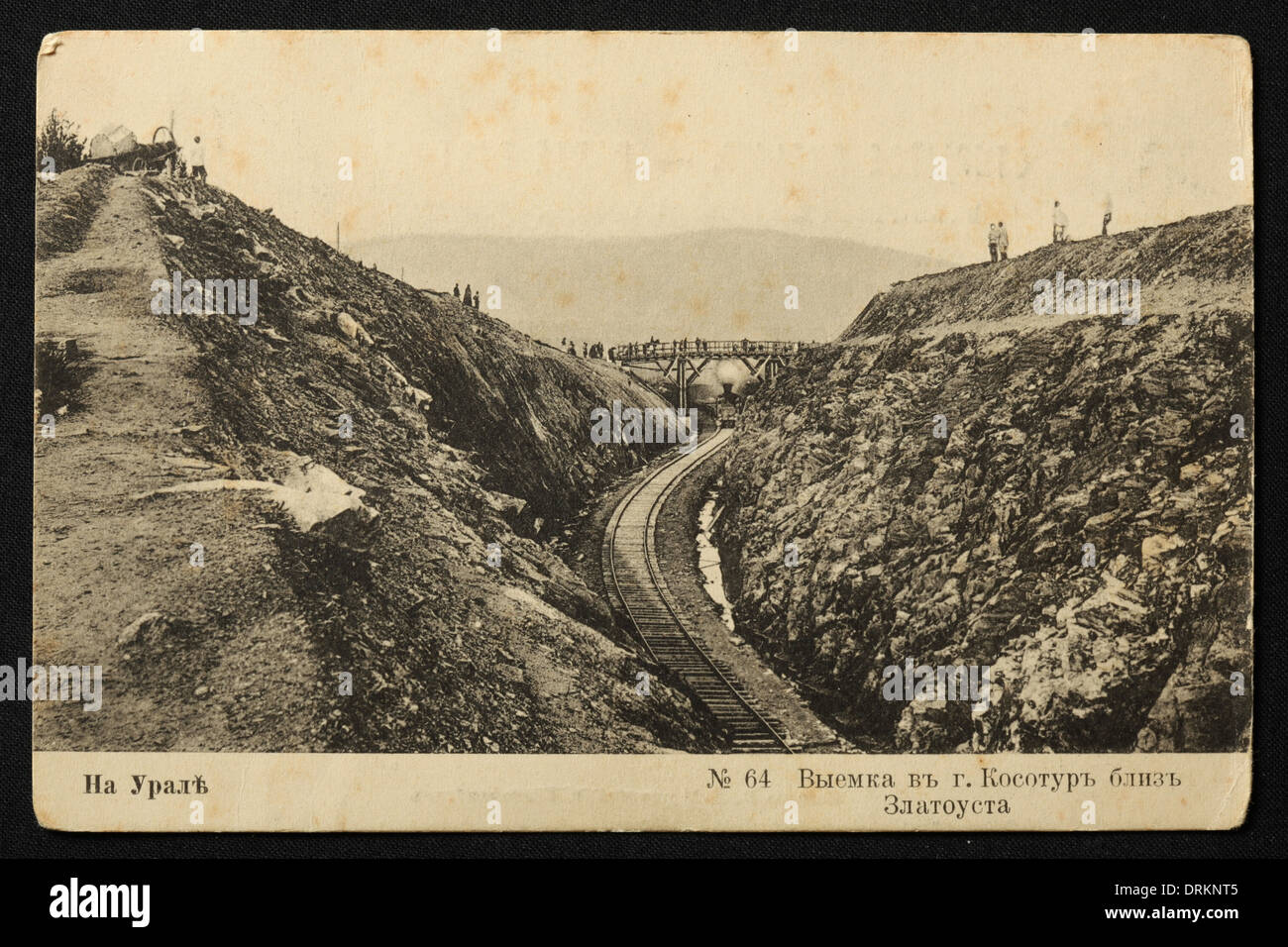 Chemin de fer TRANS-Siberian près de la gare de Zlatoust dans les montagnes de l'Oural, Empire russe. Photo vintage noir et blanc du photographe russe Veniamin Metenkov datée du début du XXe siècle, publiée dans la carte postale russe vintage publiée par Veniamin Metenkov lui-même à Yekaterinburg, Russie. Texte en russe: Dans l'Oural. Coupe dans le Mont Kosotur près de la gare de Zlatoust. Zlatoust est une ville de la région de Chelyabinsk, en Russie, située sur la rivière Ay à environ 160 km de Chelyabinsk. Avec la permission de la collection de cartes postales Azoor. Banque D'Images