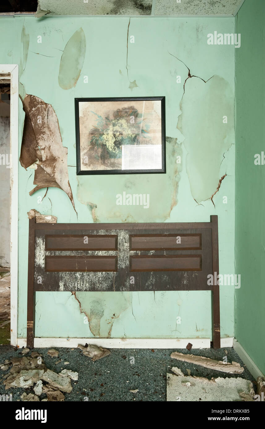 Les graphismes et la tête d'un lit sont oubliés dans une chambre dans un motel abandonné dans l'Ontario, Canada. Banque D'Images