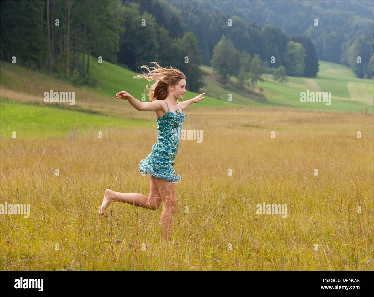 L'Autriche, Salzkammergut, Mondsee, young woman running in a meadow Banque D'Images