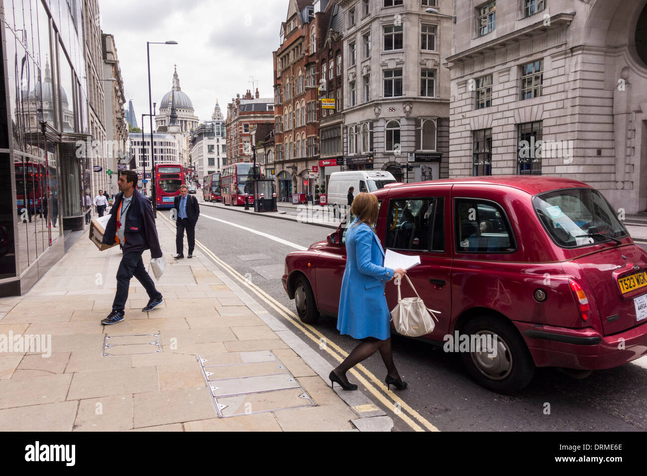 Femme en manteau bleu entrer dans taxi noir à Londres, Royaume-Uni Banque D'Images