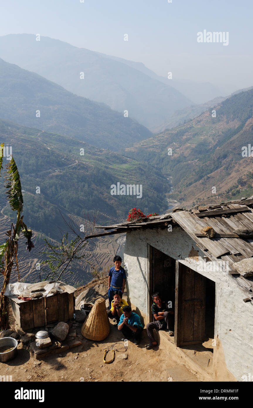 Une famille népalaise sur leur ferme à la recherche au curieux spectacle de trekkeurs de passage Banque D'Images