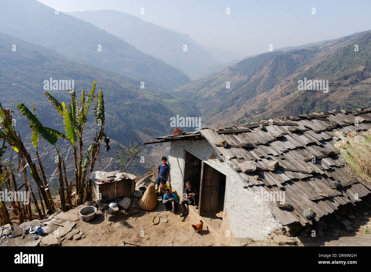 Une famille népalaise sur leur ferme à la recherche au curieux spectacle de trekkeurs de passage Banque D'Images