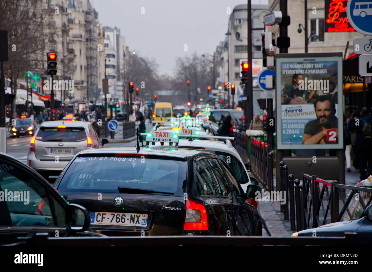 Les taxis de l'alignement dans une rue animée à l'heure de pointe à Paris, France. Banque D'Images