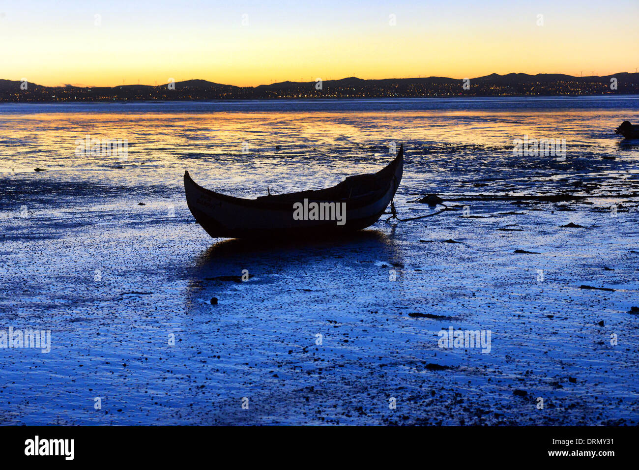 Un bateau de pêche de coquillages sur la rivière Tejo, Alcochete, Portugal au coucher du soleil. Banque D'Images