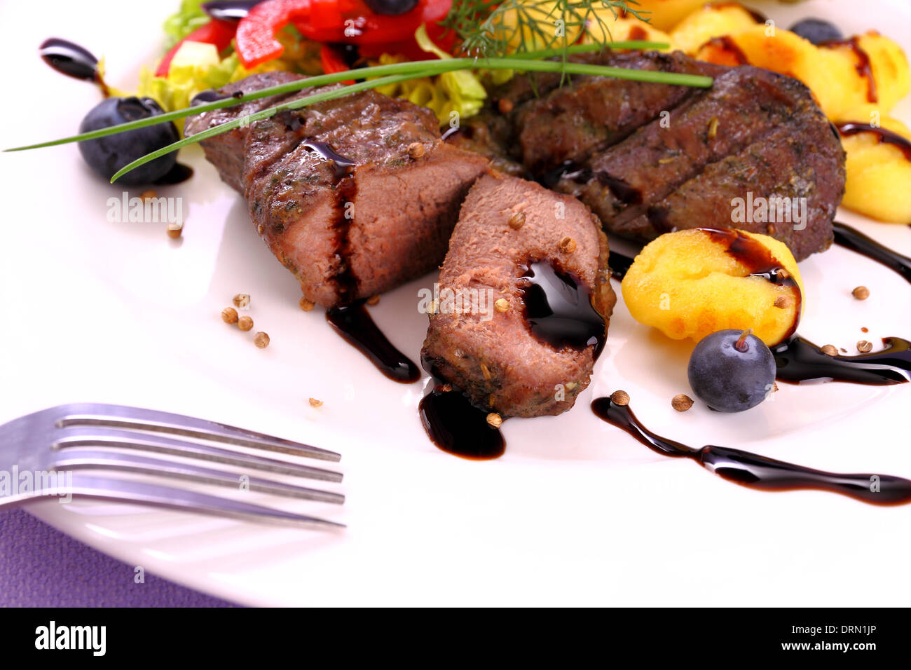Steak d'agneau avec des pommes de terre, légumes et sauce balsamique, Close up Banque D'Images