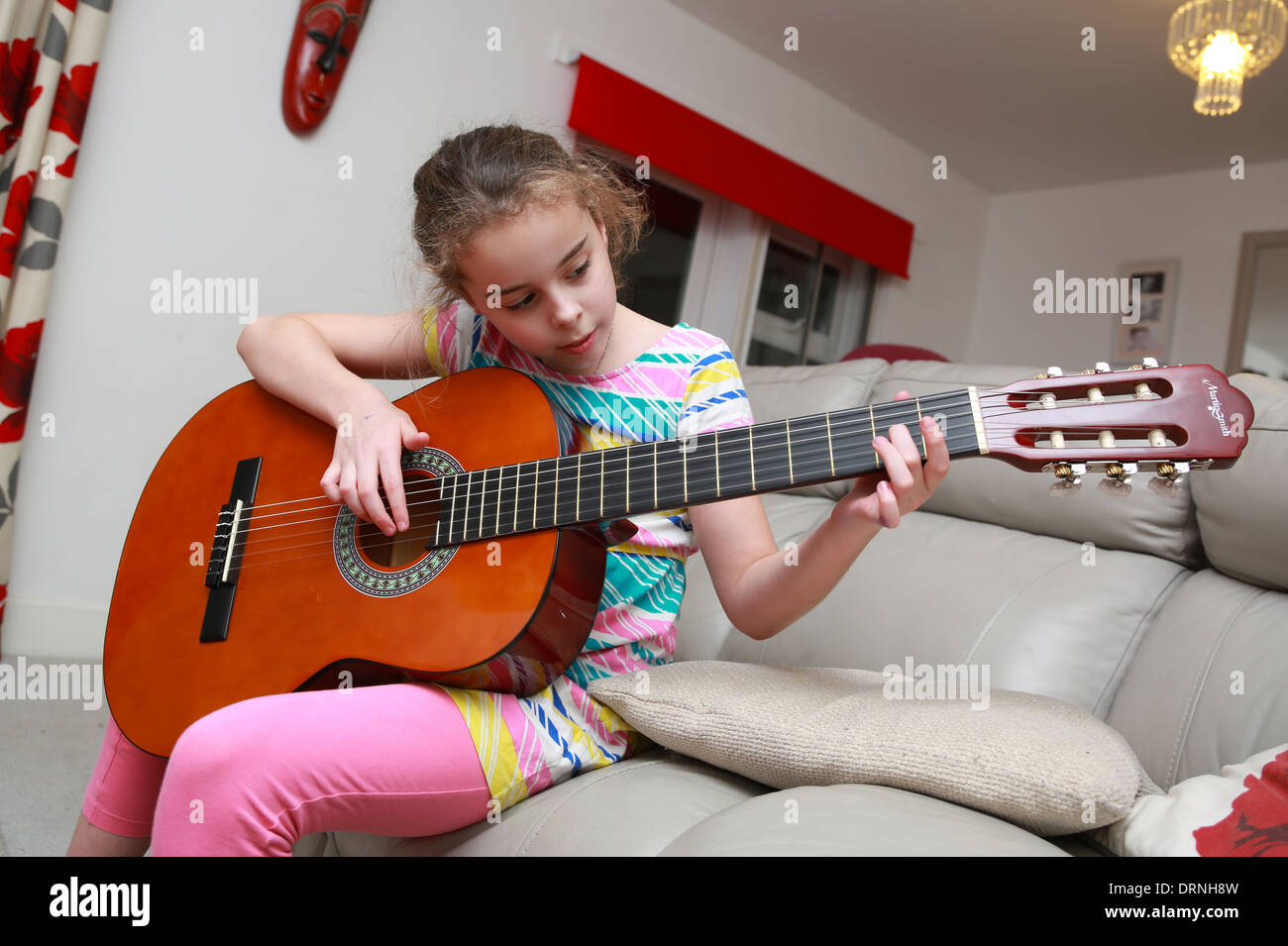 9 ans, fille d'apprendre à jouer de la guitare Banque D'Images