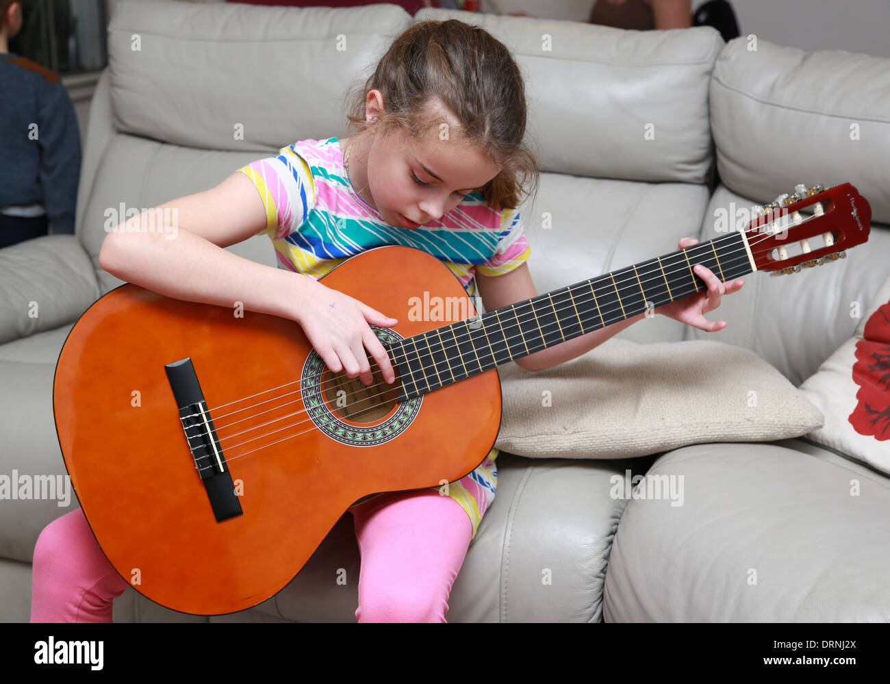 9 ans, fille d'apprendre à jouer de la guitare Banque D'Images