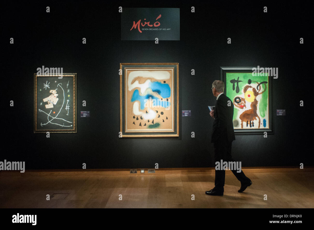 Londres, Royaume-Uni - 30 janvier 2014 : un homme marche dernières peintures de Joan Miro qui seront en vente le 4 février chez Christie's. De G à D : 'personnage et étoile dans la nuit", "Le chant des oiseaux en automne' et 'femme et oiseaux' Crédit : Piero Cruciatti/Alamy Live News Banque D'Images