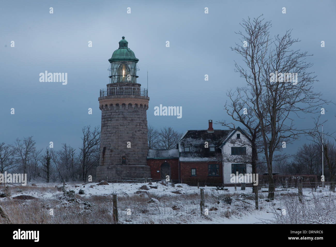 Le light house sur Knude marteau au crépuscule. L'hiver est arrivé et la terre est recouverte de neige. Banque D'Images