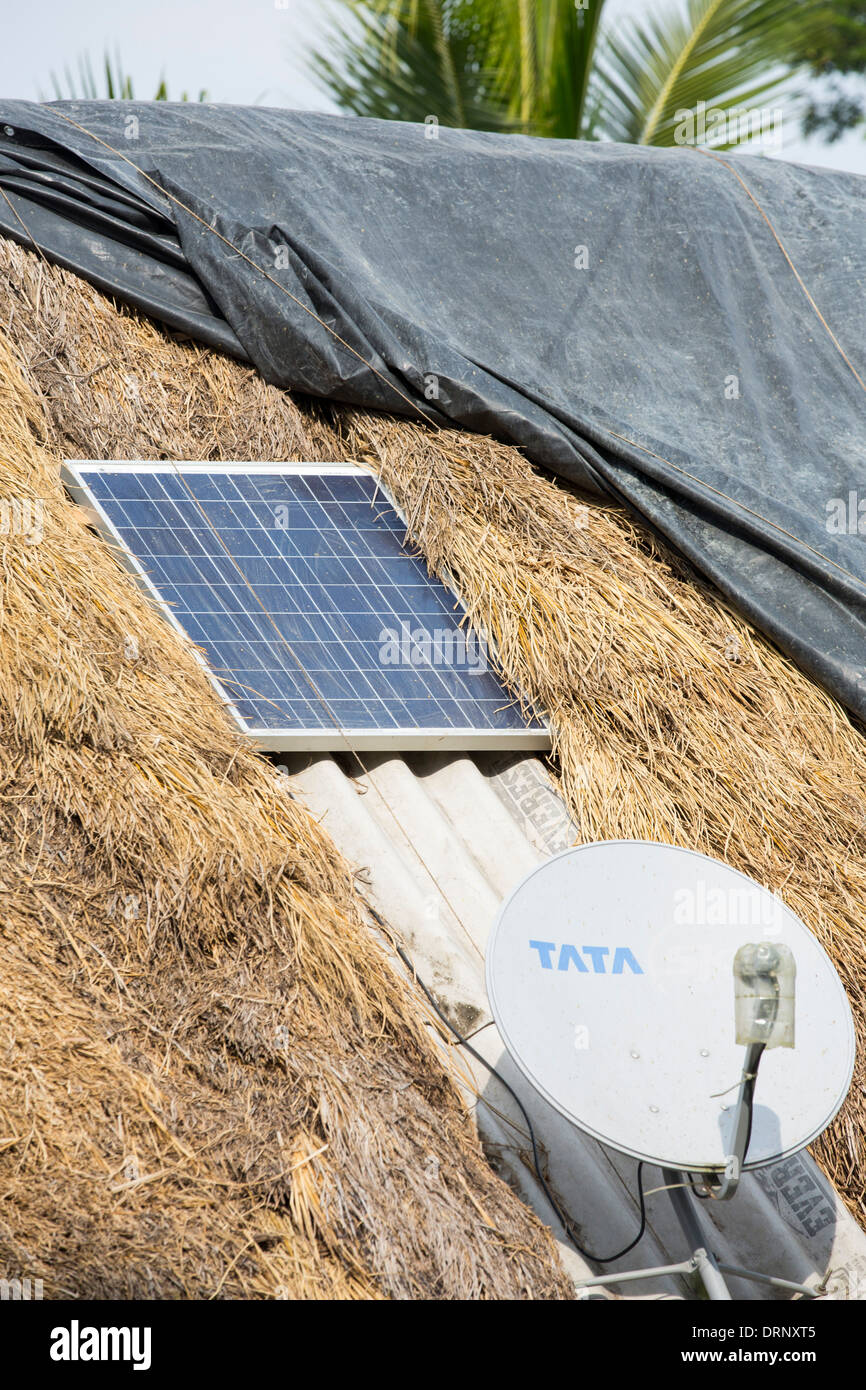 Une cabane de torchis avec un petit panneau solaire et satelite lave dans les Sunderbans, une zone de basse altitude du delta du Gange dans l'Est de l'Inde Banque D'Images