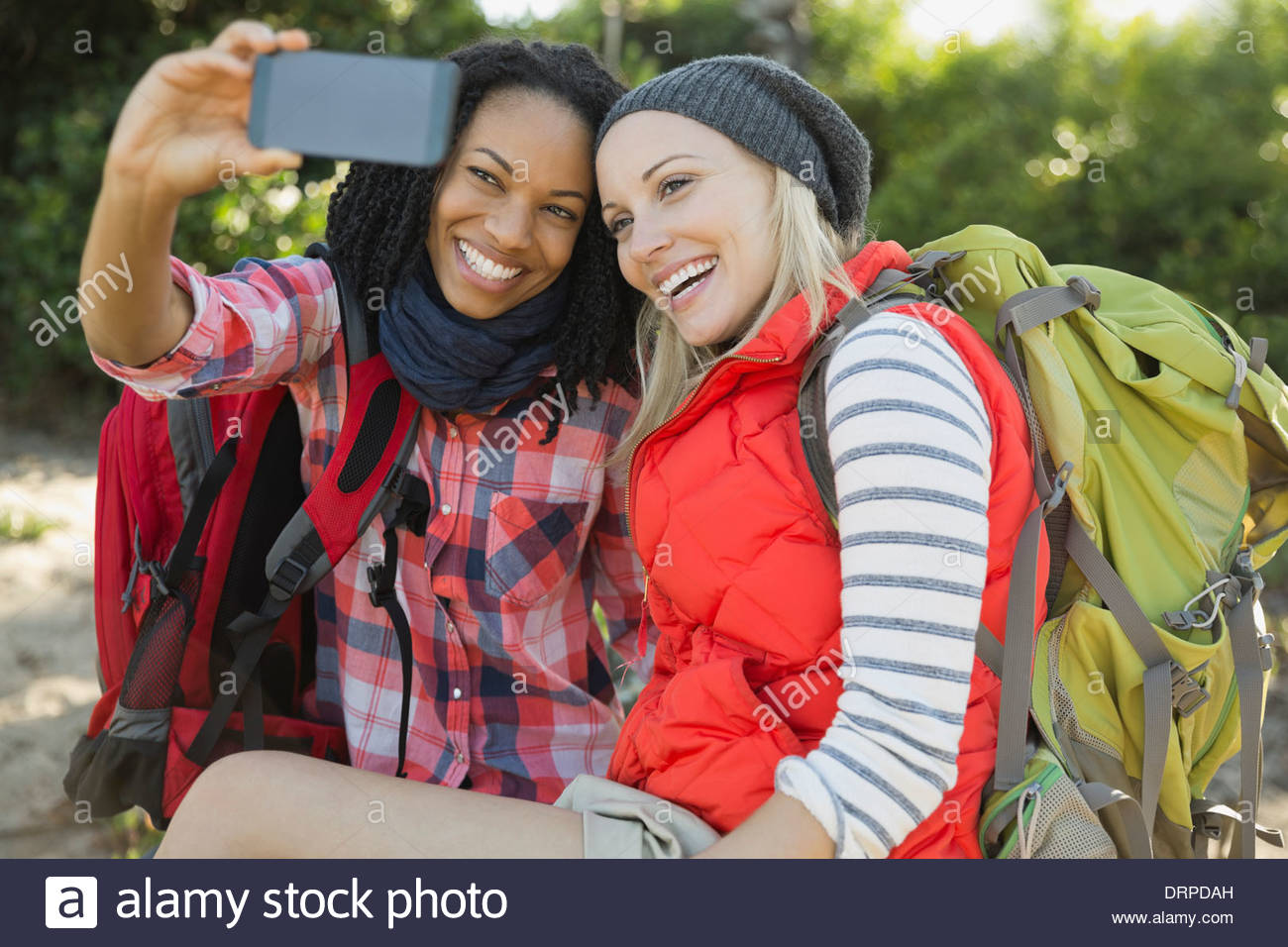 Femme backpackers taking self portrait with smart phone Banque D'Images