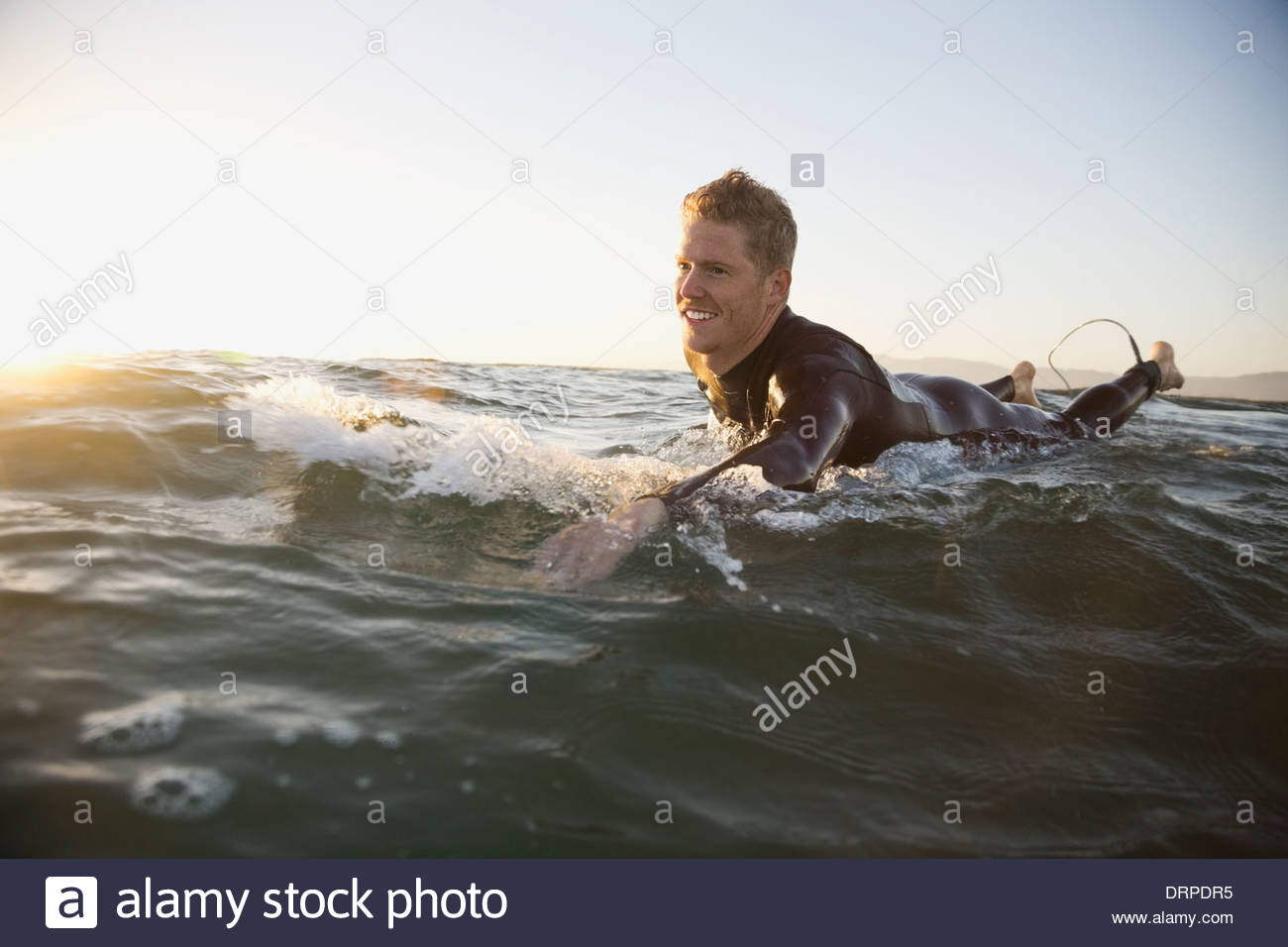 Man paddling on surfboard Banque D'Images