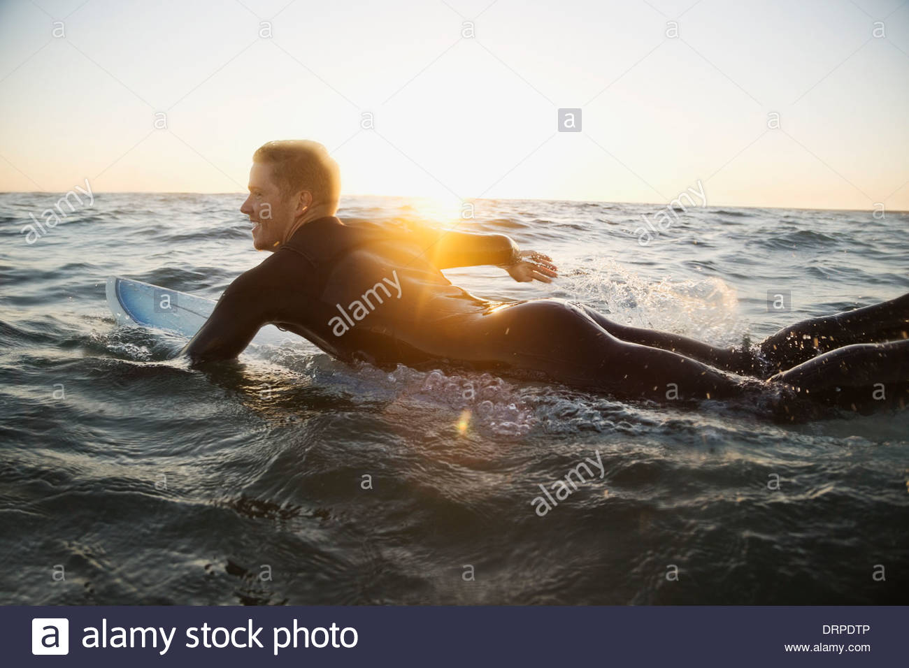 Man paddling on surfboard Banque D'Images
