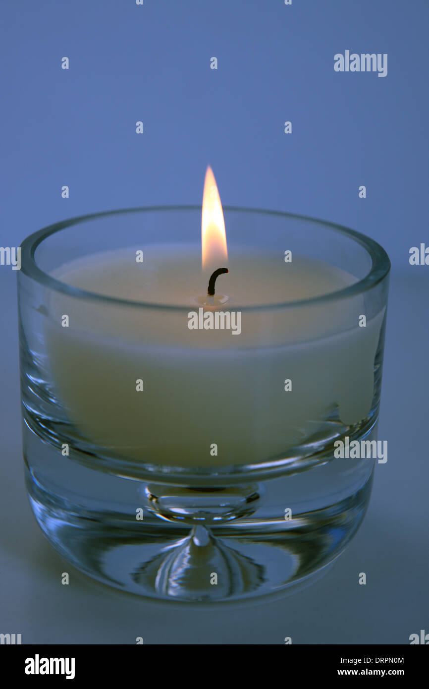 Bougie et flamme dans un récipient en verre épais Banque D'Images
