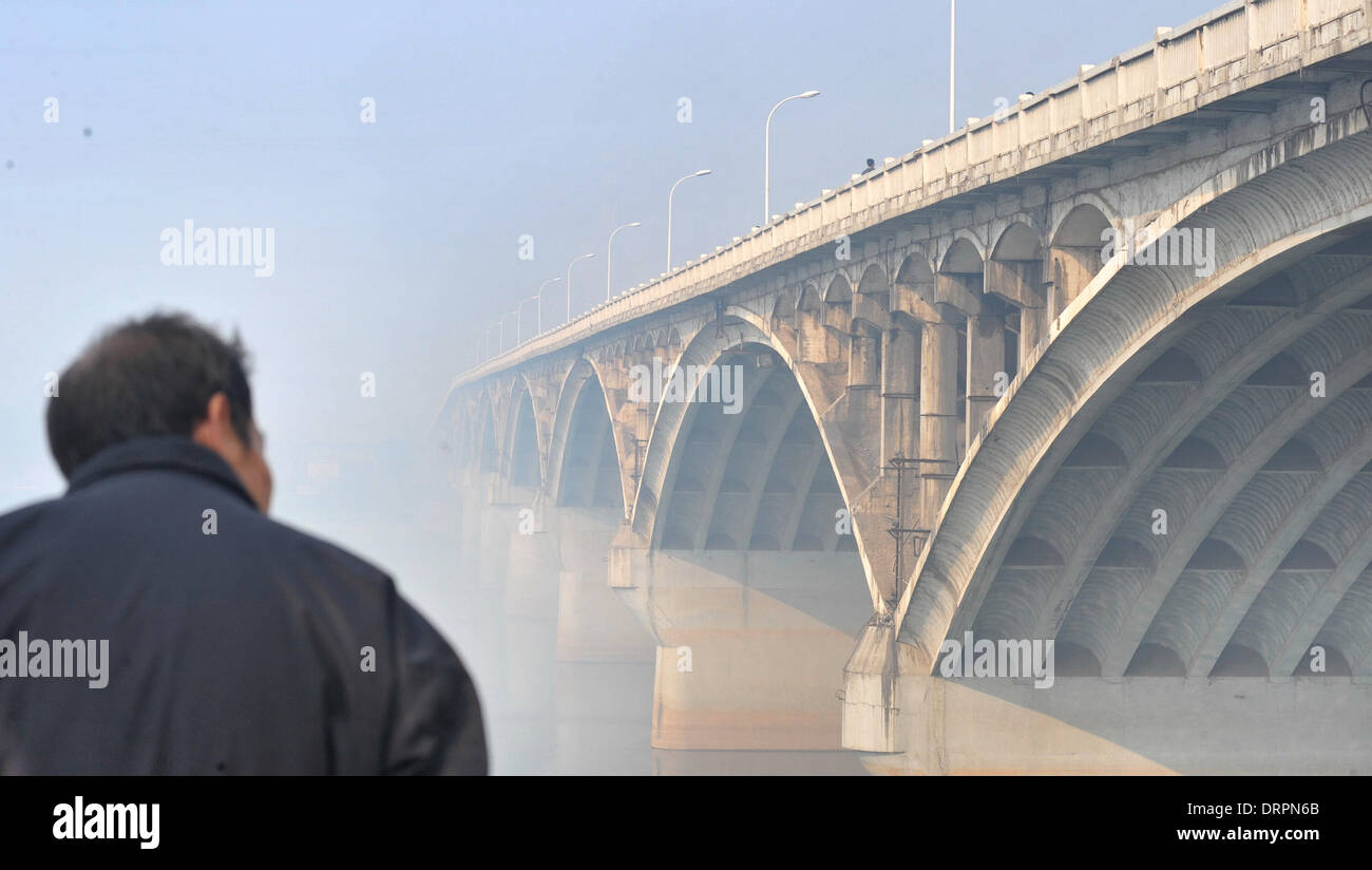 Changsha, Chine, province du Hunan. Jan 31, 2014. Un homme vues Juzizhou Bridge voilé de smog lourde à Changsha, capitale de la province du Hunan en Chine centrale, le 31 janvier 2014. Un épais brouillard entoure la capitale en raison de l'air froid inactif le vendredi, réduisant la visibilité et la pollution atmosphérique dans la région. Credit : Long Hongtao/Xinhua/Alamy Live News Banque D'Images