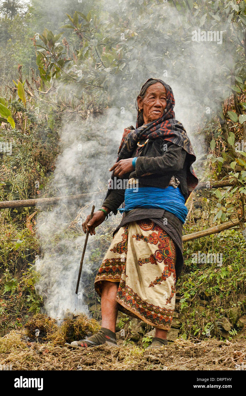 Vieille Femme et un incendie dans l'Annapurnas, Népal Banque D'Images