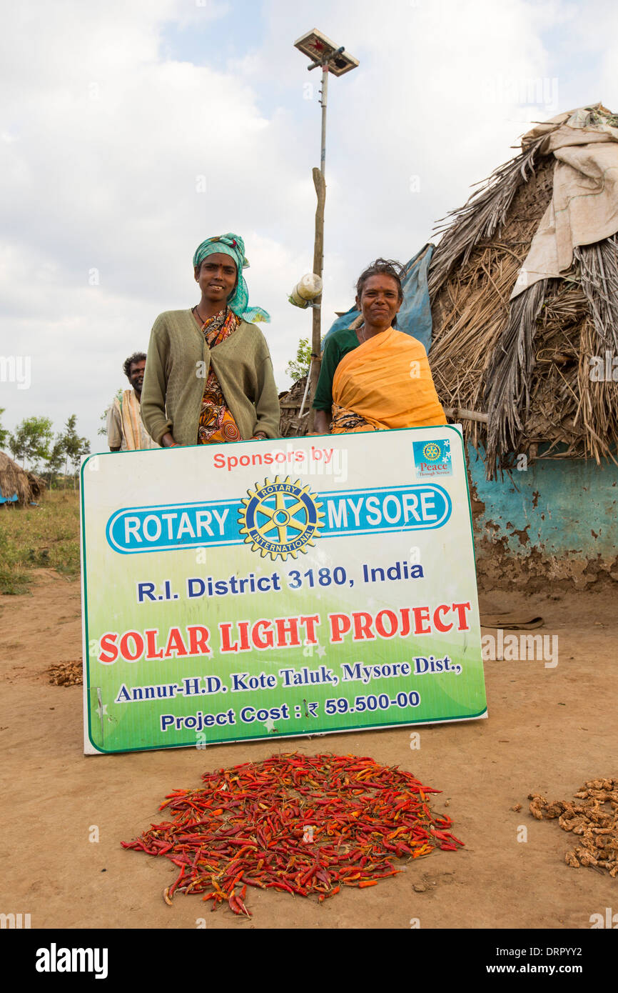 Une famille intouchable en dehors de leur hutte, éclairé par une lumière électrique, alimenté par un panneau solaire de format A4 Banque D'Images