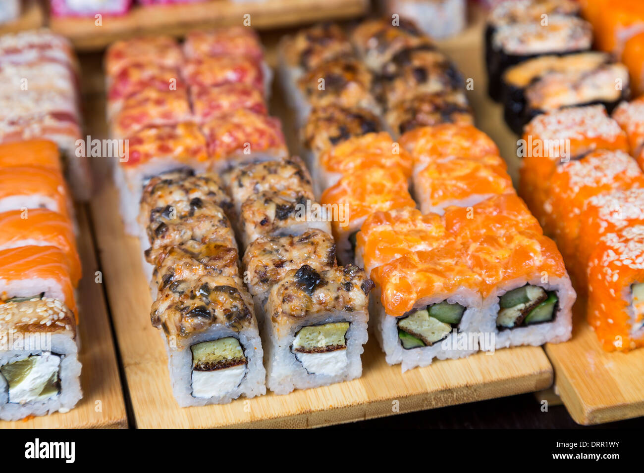Assortiment de sushi et de rouleaux sur bois board en lumière sombre Banque D'Images