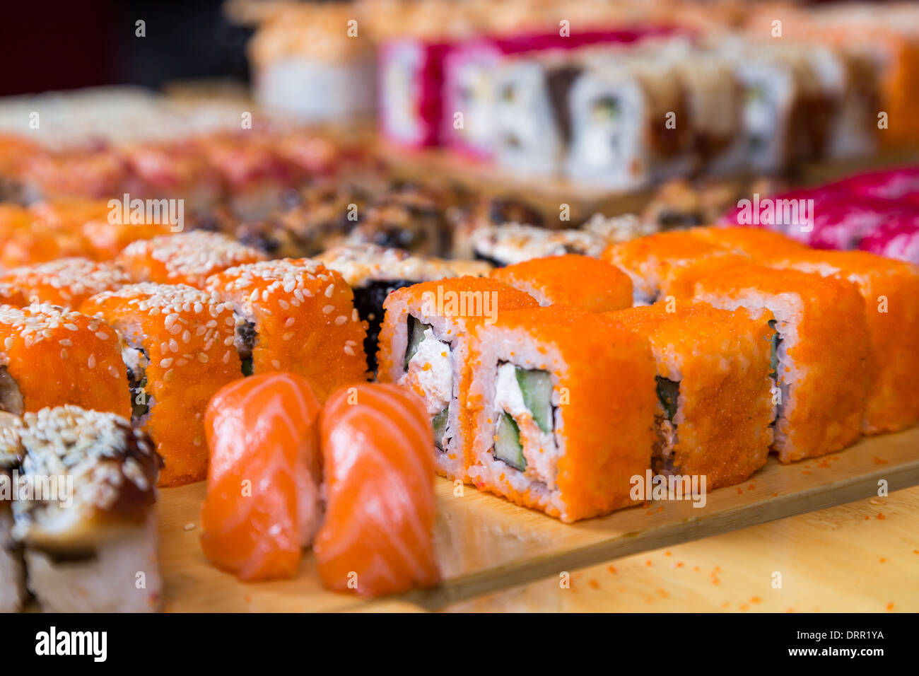 Assortiment de sushi et de rouleaux sur bois board en lumière sombre Banque D'Images
