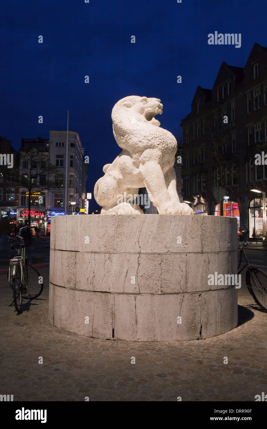 Sculpture de Lion sur la place du Dam la nuit en Hollande, aux Pays-Bas. Banque D'Images