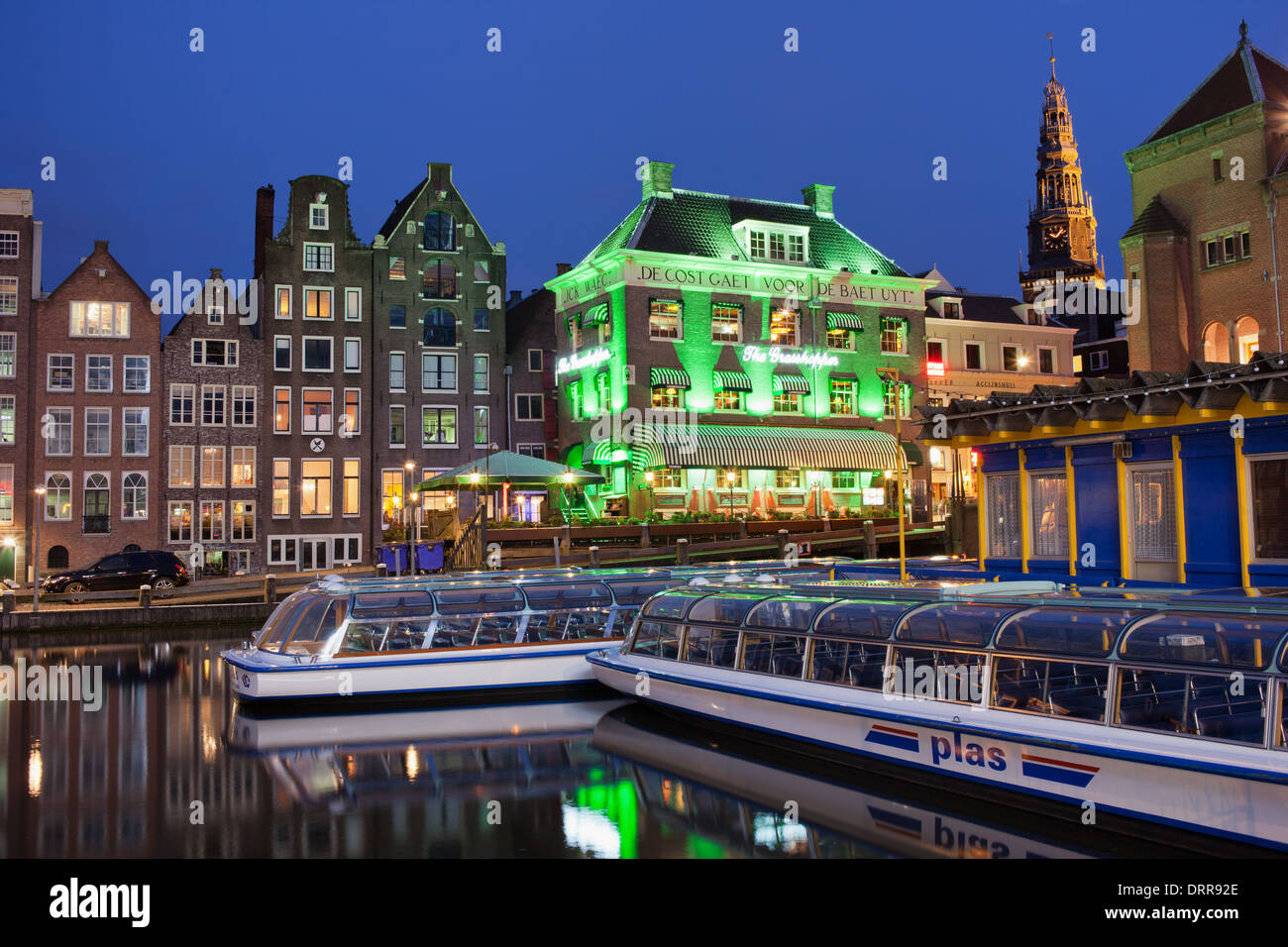 Vieille ville d'Amsterdam par nuit, les bateaux de croisière sur un canal historique et des maisons en terrasse dans le vieux centre de la ville. Banque D'Images