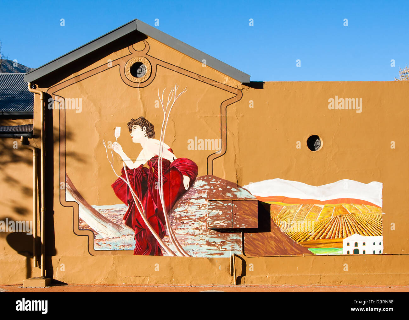 Peinture murale d'une femme de boire du vin sur le mur d'une usine de vignoble dans l'ouest du Cap, en Afrique du Sud Banque D'Images