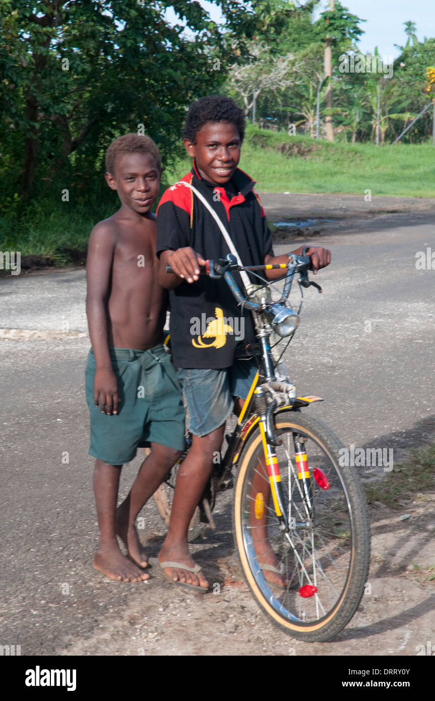 Les garçons avec un vélo dans le rues de Kavieng, capitale de la province de Nouvelle-irlande, Papouasie Nouvelle Guinée Banque D'Images