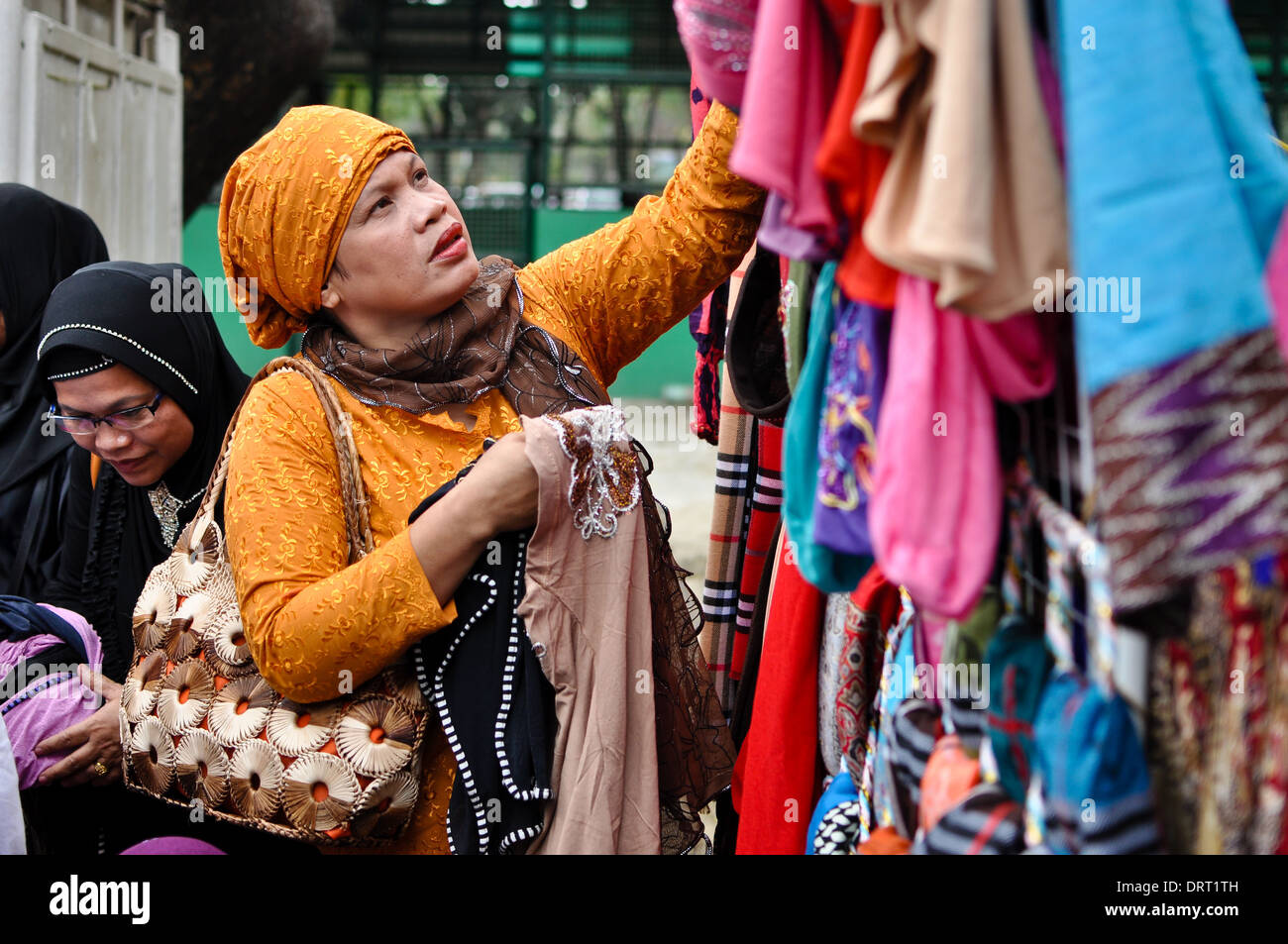 Une femme regarde l'Islam hidjab, casquettes, affichée à la célébration de la Journée mondiale de Hijab au CIR du souvenir de Quezon Banque D'Images