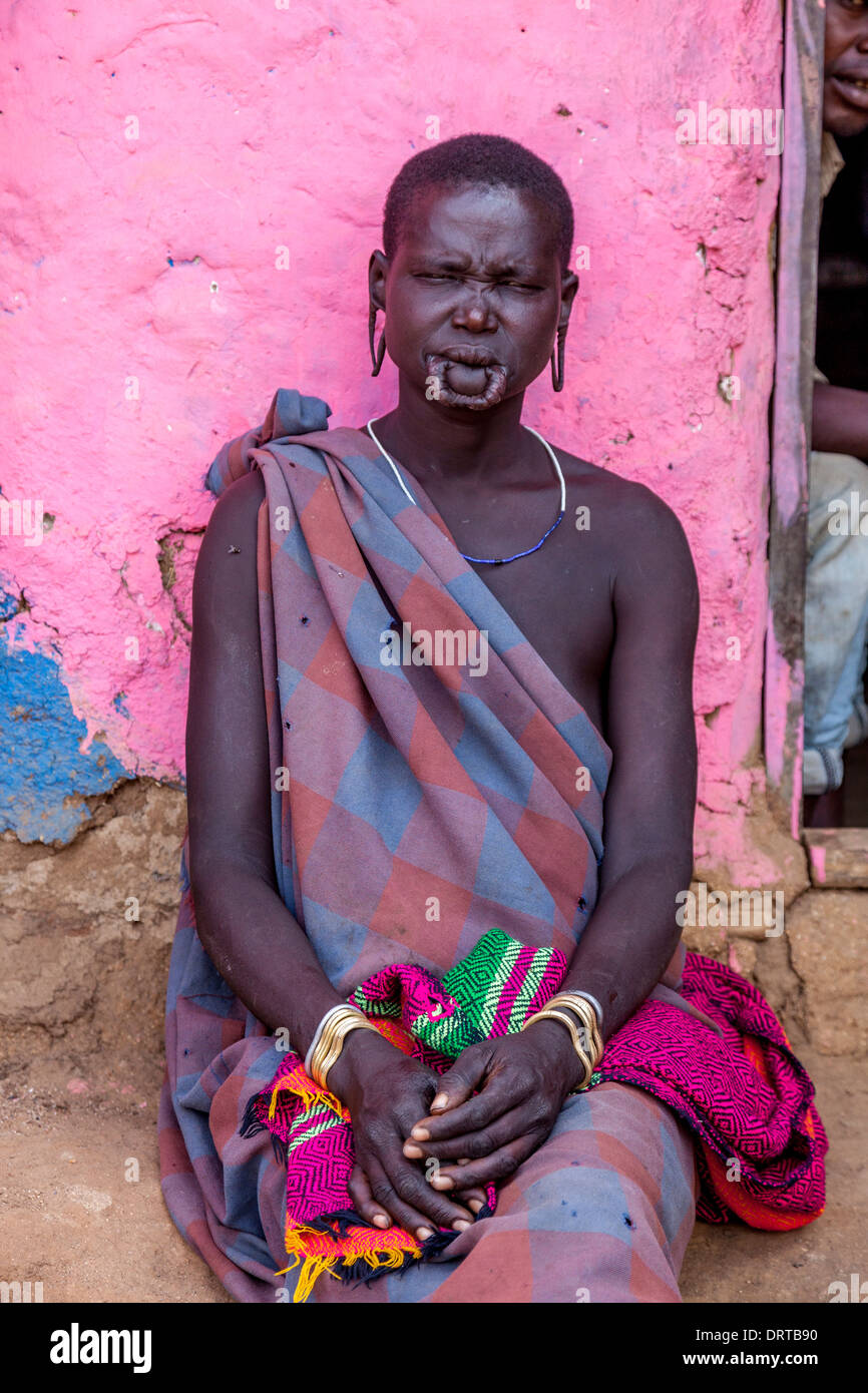 Morsi femme assise à l'extérieur d'une maison, Jinka, vallée de l'Omo, Ethiopie Banque D'Images