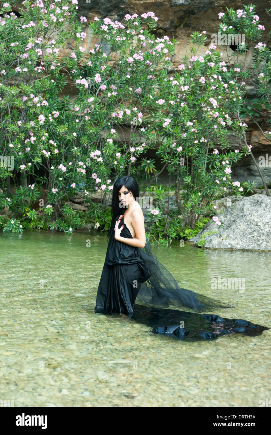 Modèle féminin posant dans un noir à l'intérieur de la rivière Savannah Banque D'Images