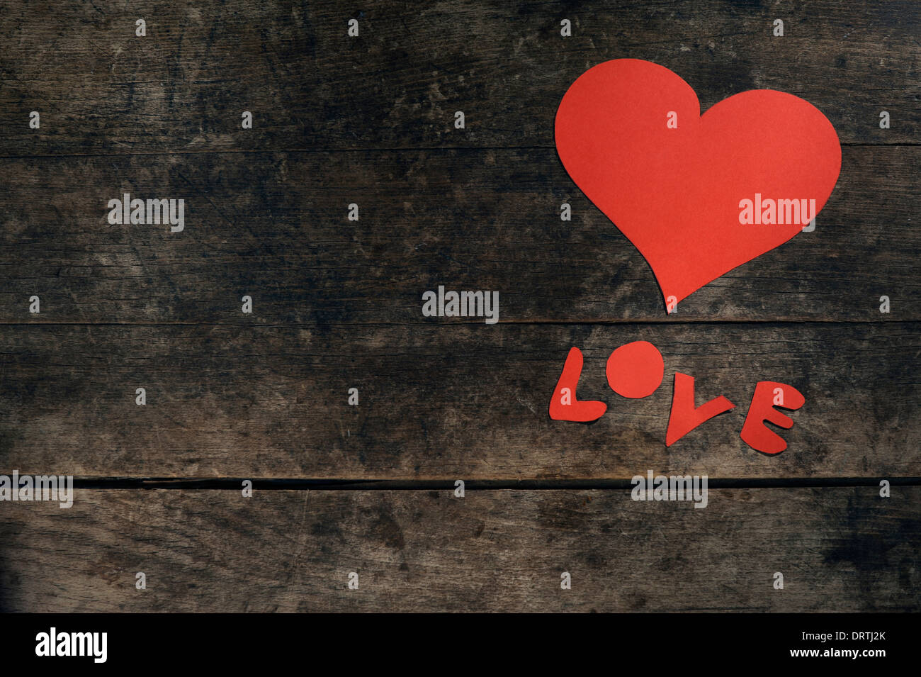 Message d'amour créatif : coeur fait main et le mot 'Amour' écrit en lettres de papier sur une table en bois vintage. Banque D'Images