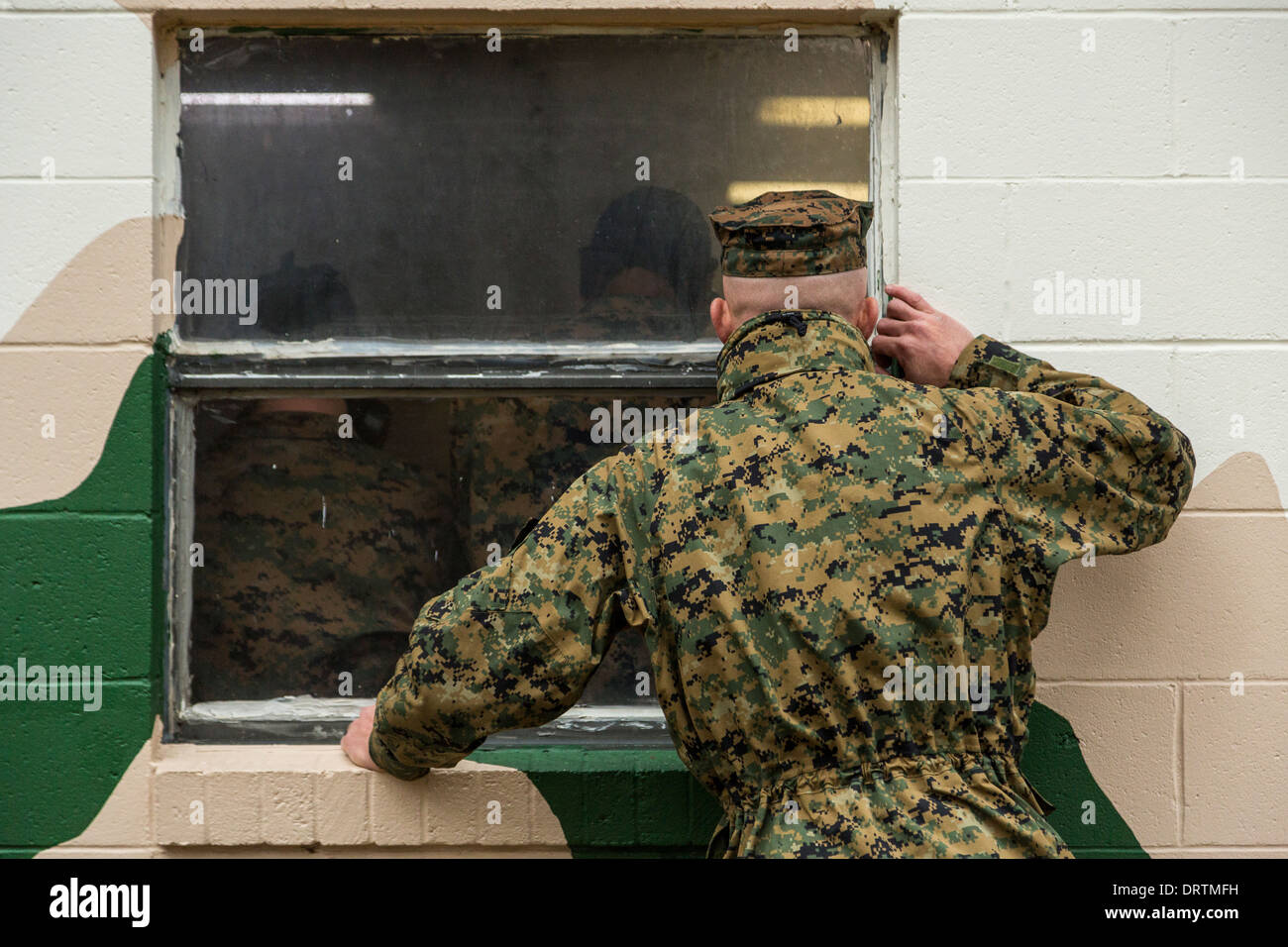 Les instructeurs de l'US Marine percer si le pic des fenêtres de la chambre à gaz regarder recrute au cours de boot camp, le 13 janvier 2014 à Parris Island, SC. Banque D'Images