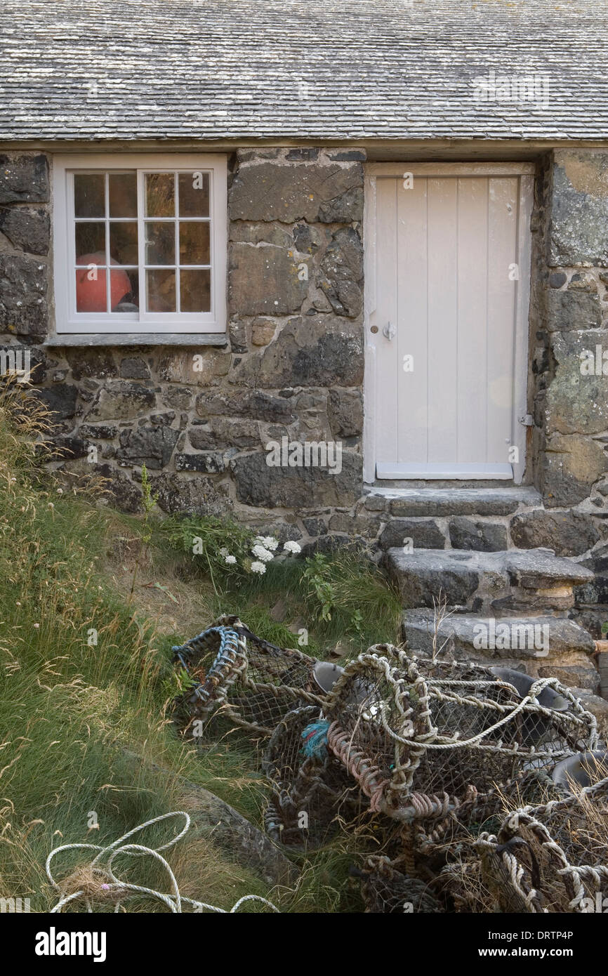 Des casiers à homard empilés à l'extérieur d'un hangar à Fisherman's Cove à meneaux, Cornwall, Angleterre. Banque D'Images